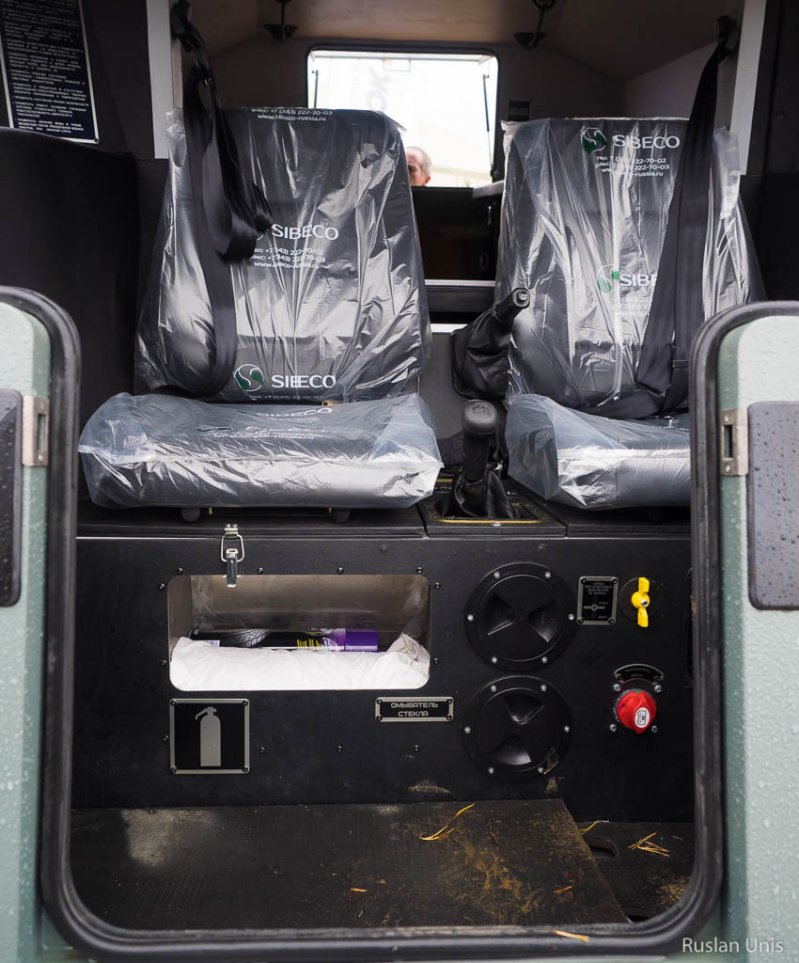 С такого ракурса видны некоторые элементы управления машиной: ручной тормоз, рычаг коробки передач, кран регулировки давления в шинах и выключатель массы: